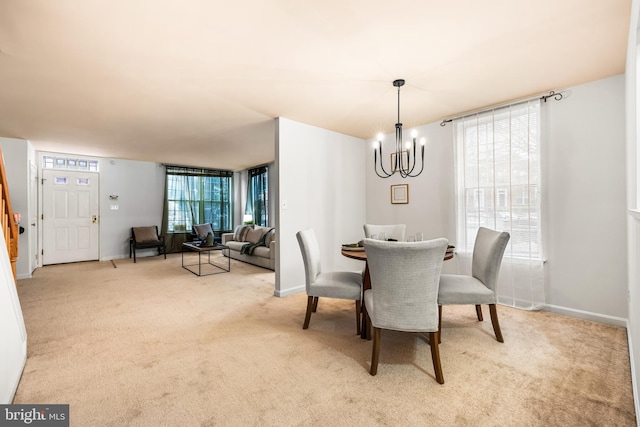 dining space with light carpet and an inviting chandelier