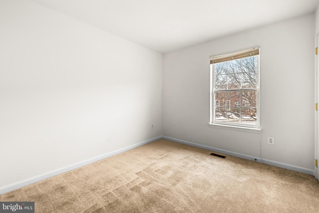 spare room featuring light colored carpet