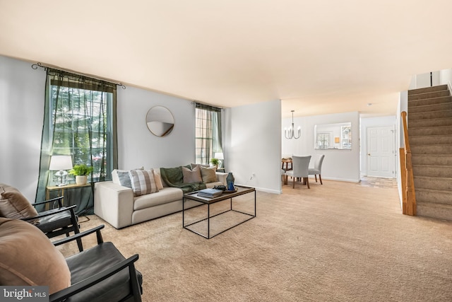 carpeted living room featuring a notable chandelier