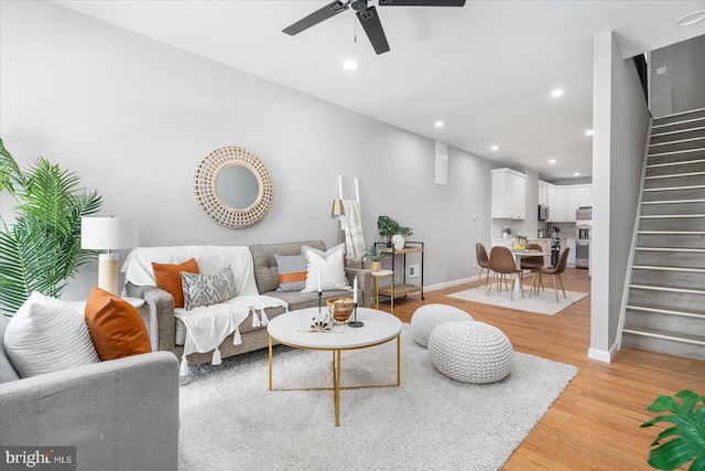 living room featuring light wood-type flooring and ceiling fan