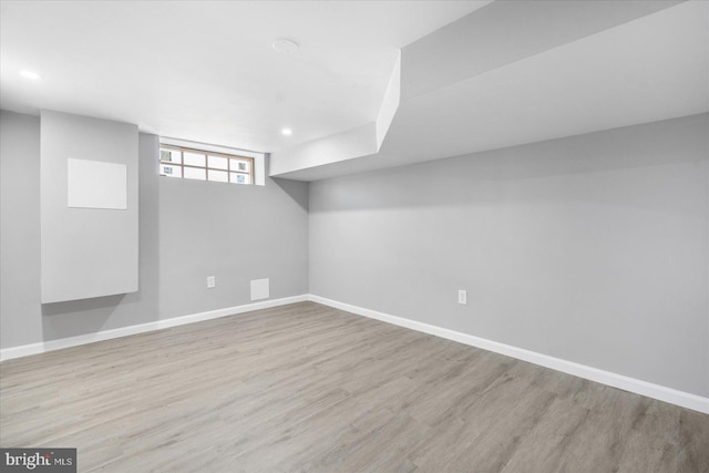 basement with light hardwood / wood-style flooring