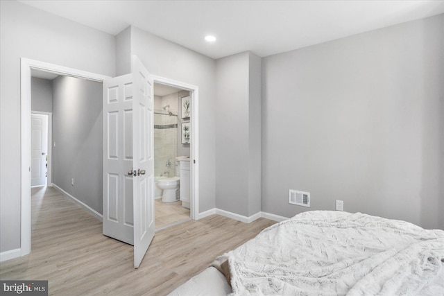 bedroom featuring ensuite bathroom and light hardwood / wood-style flooring