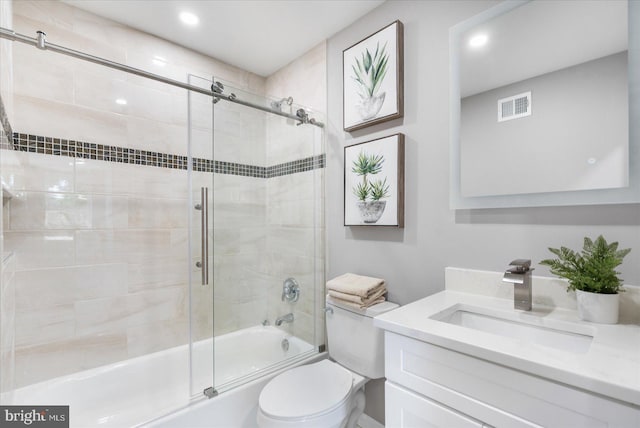 full bathroom with vanity, enclosed tub / shower combo, and toilet