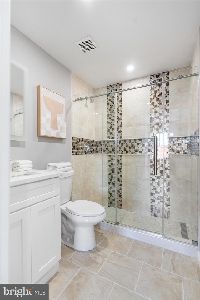 bathroom featuring vanity, toilet, and walk in shower