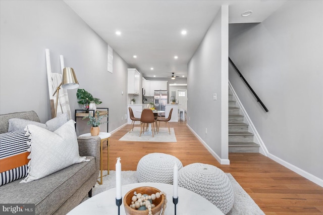 living room featuring light wood-type flooring and ceiling fan