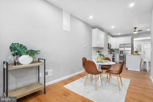 dining area featuring ceiling fan and light wood-type flooring