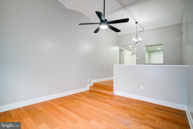 unfurnished room with hardwood / wood-style floors and ceiling fan with notable chandelier