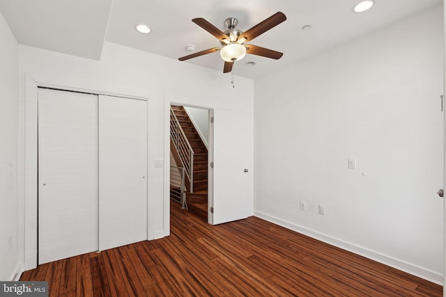 unfurnished bedroom with ceiling fan, dark wood-type flooring, and a closet