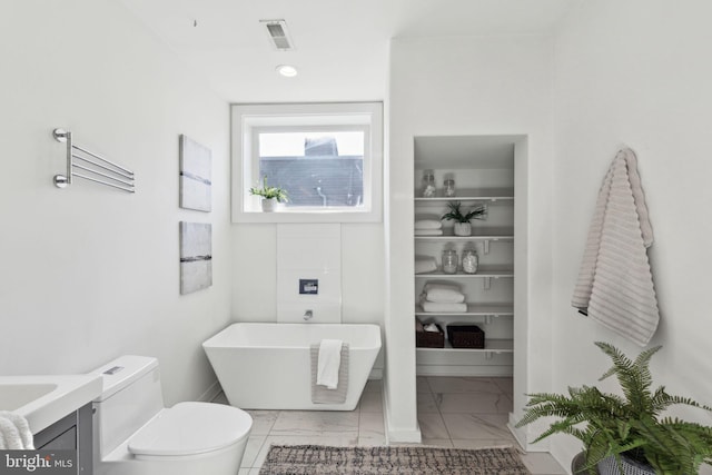 bathroom with a bathing tub, vanity, and toilet