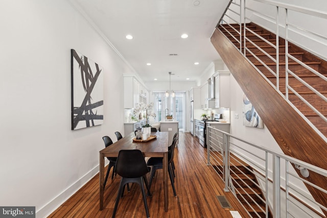 dining room featuring crown molding, dark wood-type flooring, and a chandelier