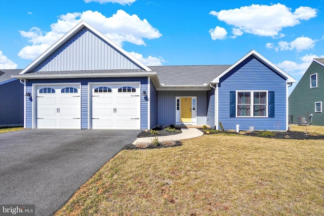 single story home featuring a front yard, a shingled roof, a garage, aphalt driveway, and board and batten siding