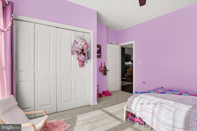 carpeted bedroom featuring a closet, visible vents, and ceiling fan