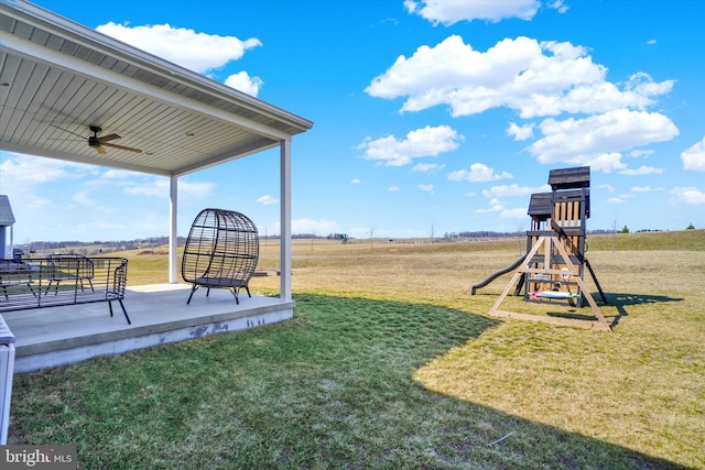 view of yard featuring a playground, a patio area, and ceiling fan