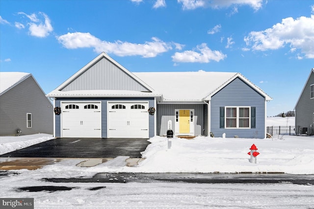 view of front facade featuring aphalt driveway, cooling unit, a garage, and board and batten siding