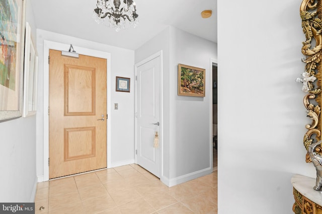 foyer with light tile patterned flooring and an inviting chandelier