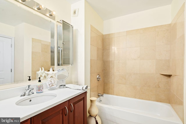 bathroom with vanity and tiled shower / bath