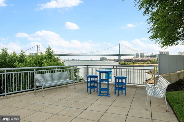 view of patio with a balcony and a water view