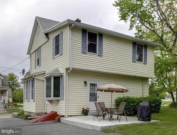 back of property featuring a patio area and a yard