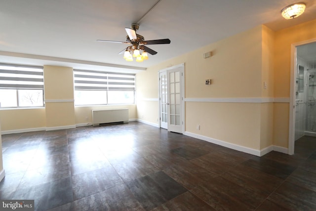 spare room featuring ceiling fan, radiator heating unit, and french doors