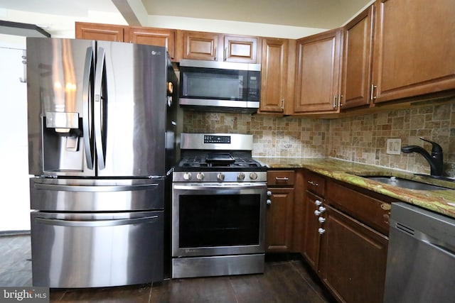 kitchen with sink, light stone countertops, stainless steel appliances, and tasteful backsplash