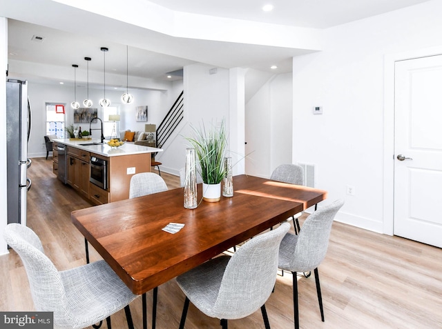 dining space featuring light hardwood / wood-style floors and sink