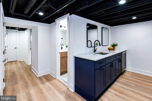 interior space with sink, light wood-type flooring, and blue cabinetry