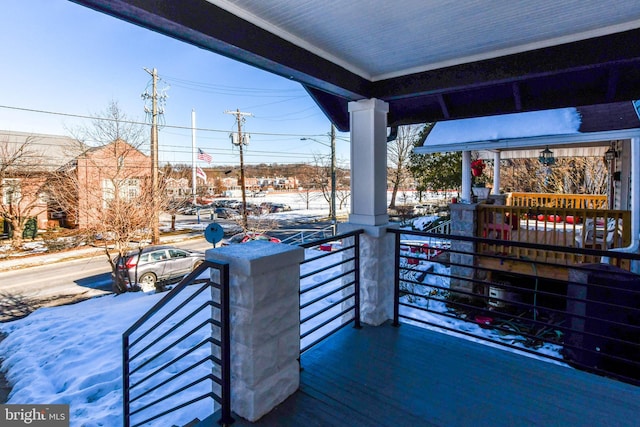 snow covered patio with a porch