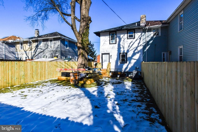 view of snow covered rear of property