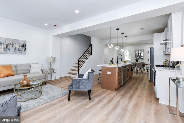 living room featuring sink and light hardwood / wood-style floors