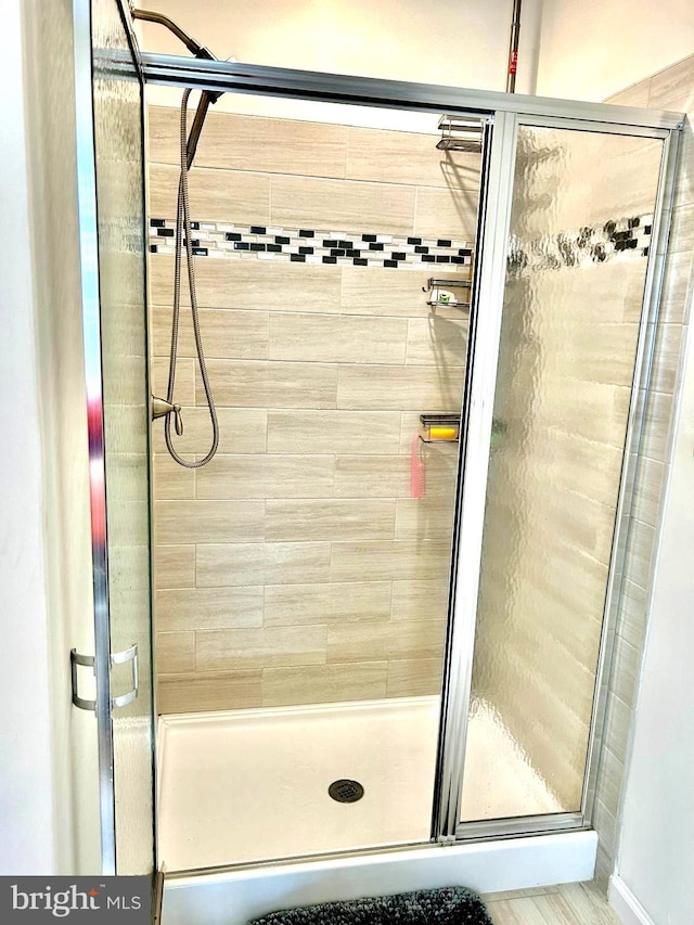 bathroom featuring a shower with door