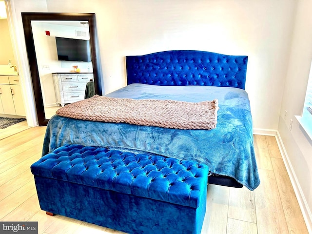 bedroom featuring light hardwood / wood-style flooring and sink