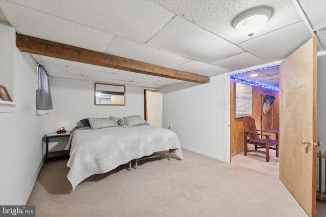 bedroom featuring a paneled ceiling and light carpet