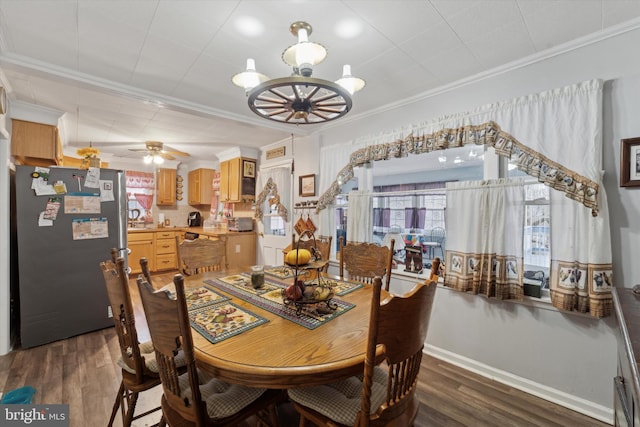 dining space with ceiling fan with notable chandelier, ornamental molding, and dark hardwood / wood-style flooring