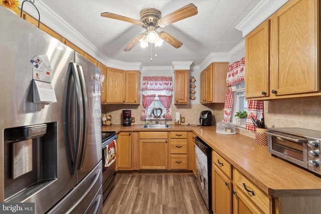 kitchen with stainless steel appliances, a wealth of natural light, sink, and hardwood / wood-style flooring