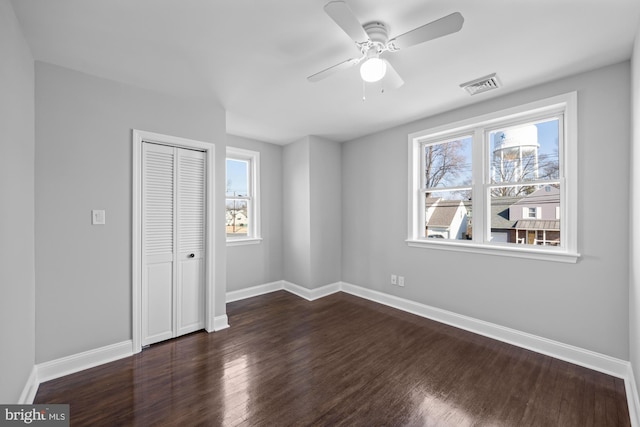 unfurnished bedroom featuring dark hardwood / wood-style flooring, a closet, and ceiling fan