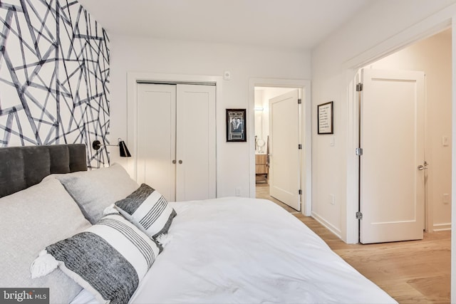 bedroom with light hardwood / wood-style flooring and a closet