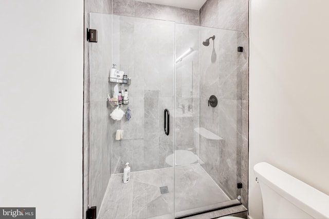 bathroom featuring an enclosed shower and toilet