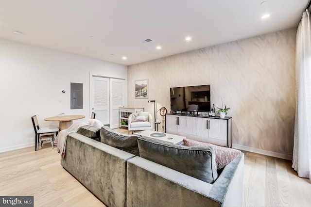 living room with electric panel and light hardwood / wood-style floors