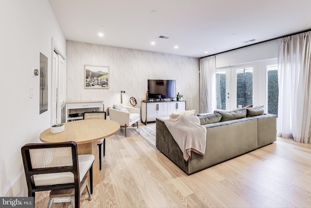 living room featuring light wood-type flooring, french doors, and electric panel