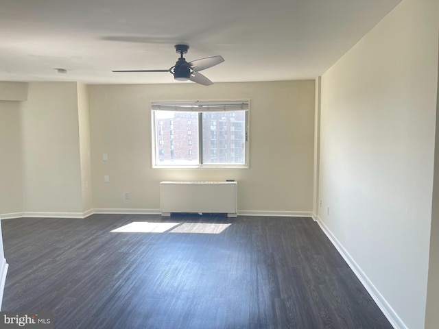 unfurnished room featuring ceiling fan, radiator heating unit, and dark hardwood / wood-style floors