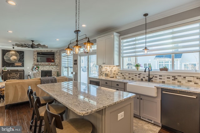 kitchen featuring a breakfast bar area, stainless steel dishwasher, plenty of natural light, and sink