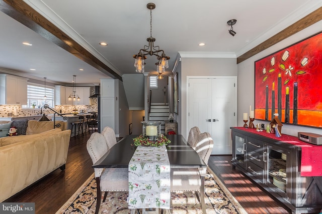 dining room with dark wood-type flooring, crown molding, and a notable chandelier