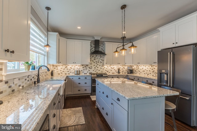 kitchen featuring white cabinetry, wall chimney exhaust hood, stainless steel appliances, and a center island