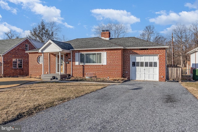 ranch-style house featuring brick siding, driveway, a chimney, and an attached garage