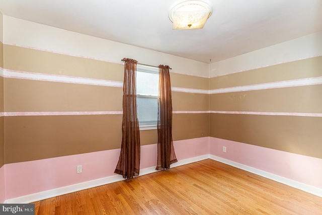 empty room with baseboards and wood finished floors