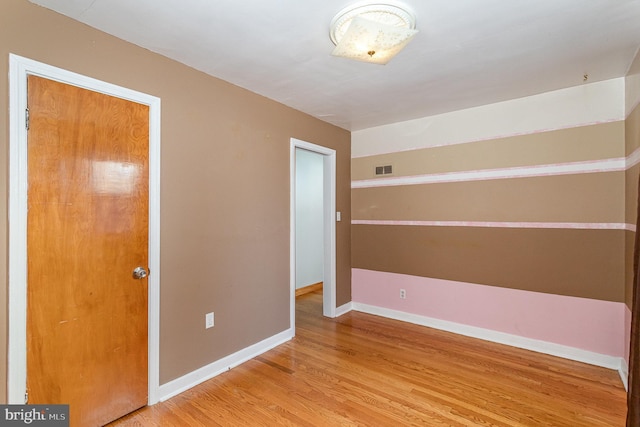 unfurnished bedroom with baseboards, visible vents, and light wood finished floors