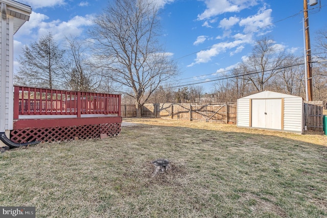 view of yard featuring an outbuilding, a fenced backyard, a wooden deck, and a shed