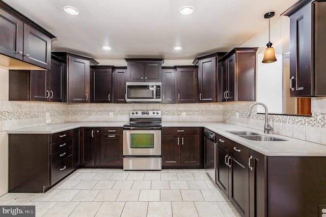 kitchen featuring appliances with stainless steel finishes, light countertops, a sink, and dark brown cabinets