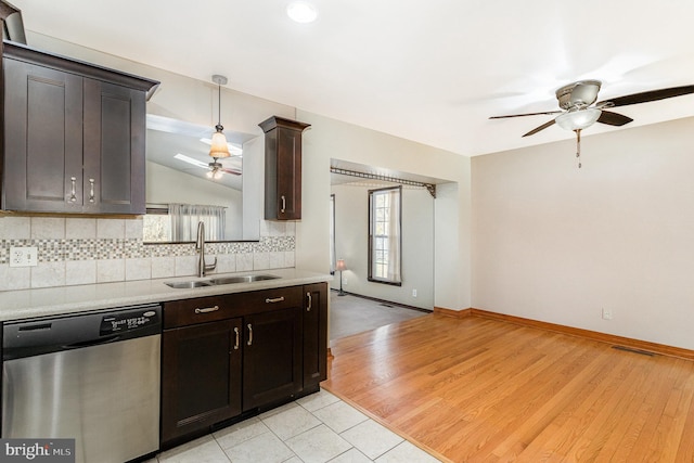 kitchen with visible vents, decorative backsplash, light countertops, stainless steel dishwasher, and a sink