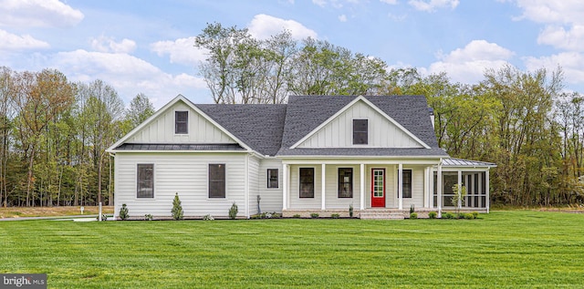 view of front of property with a standing seam roof, a front lawn, board and batten siding, and roof with shingles